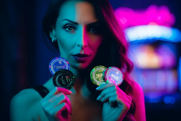 A woman smiling by bright slot machines showing lucky symbols, showcasing the exciting slot offerings at 21GAME.